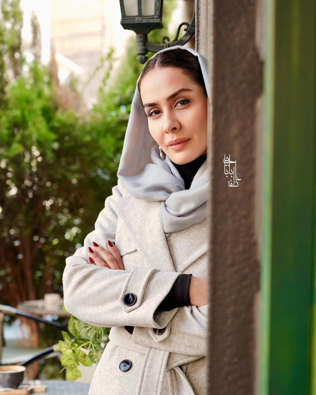 سارا والیانی با یک چهره جدی پشت درخت