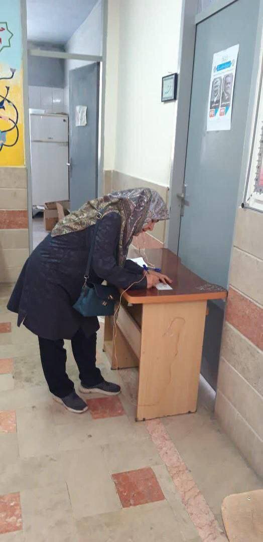 عکسی از همسر مصطفی تاج زاده با یک پلاکارد خاص پای صندوق رأی