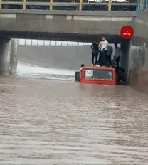 (عکس) مینی‌بوس پر از مسافر در سیل بندرعباس گیر افتاد